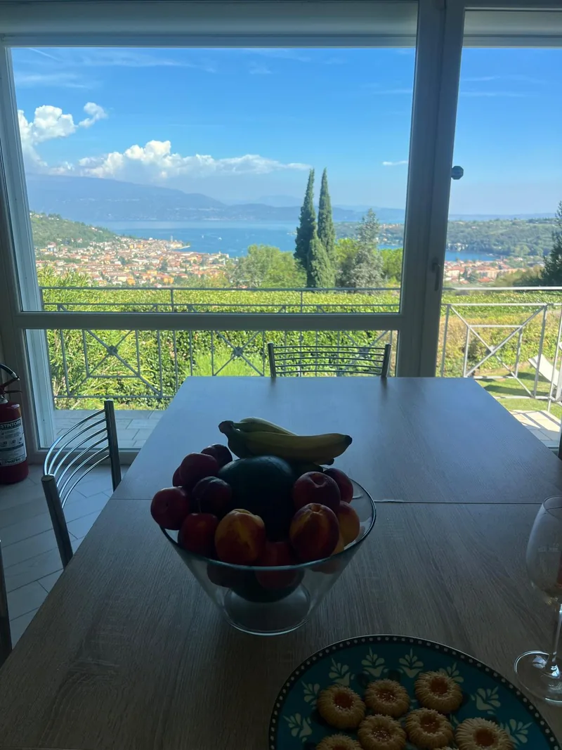 Fruit en koekjes op tafel voor het raam met uitzicht op het meer